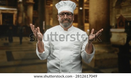 Man chef in white uniform and hat raises both hands with pleading gesture in ornate church building, looking upward; contrition.