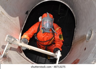  man in chemical suit entering inside cargo tank on chemical ship for cleaning operation