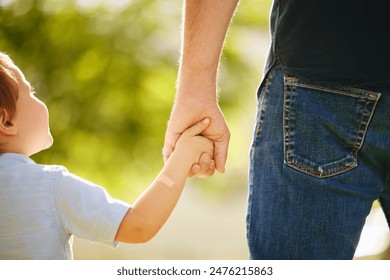 Man, child and holding hands back outdoor park together for bonding, love and support on summer vacation. Father, son and walking with care, trust and morning travel for holiday freedom of memory - Powered by Shutterstock