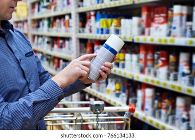 Man Chooses And Buys Chemical Products For A Car In A Store