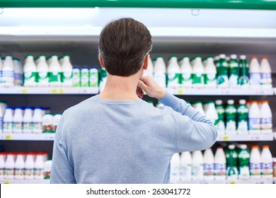 Man Chooses Dairy Products In The Store