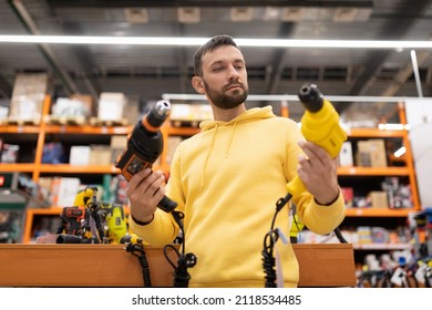 A Man Chooses A Drill For Himself As A Gift In A Construction Equipment Store