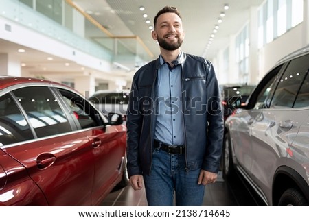 a man chooses a new car for himself walks between the rows in a car dealership