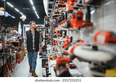 A man chooses a power tool in a hardware store.