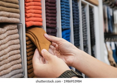 Man Chooses Socks On Sale In Department Store. Shelves With Different Color Socks In A Clothing Store. Male Shopper Selecting Sock At Store.