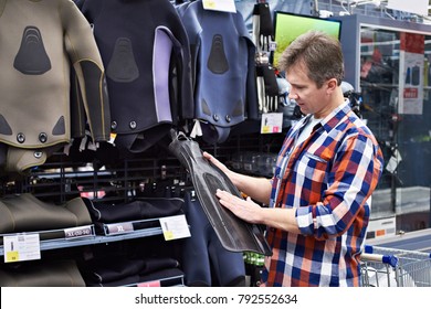 Man Chooses A Wetsuit And Fins For Spearfishing In A Sports Shop