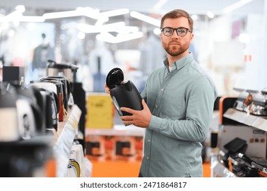 Man choosing electric kettle at store. - Powered by Shutterstock