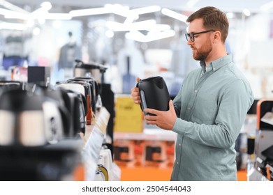 Man choosing electric kettle at store. - Powered by Shutterstock