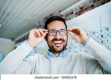 Man Is Choosing Glasses In Optics Store. 