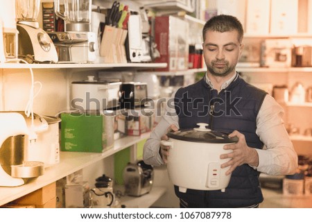 Man is choosing multivariate for his kitchen in store.