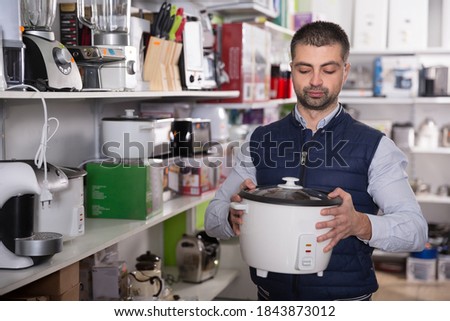 Man is choosing multivariate for his kitchen in store.