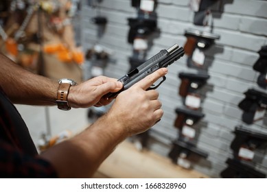 Man Choosing New Handgun In Gun Shop