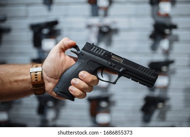 Man Choosing New Handgun In Gun Shop