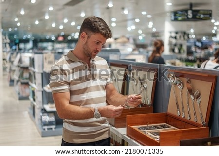 Man choosing silverware in store