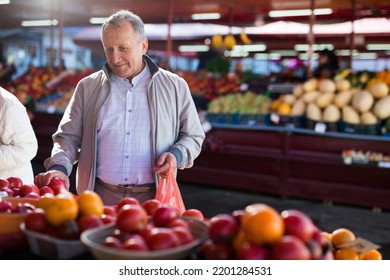 Man Choosing Tomatoes In Greengrocery