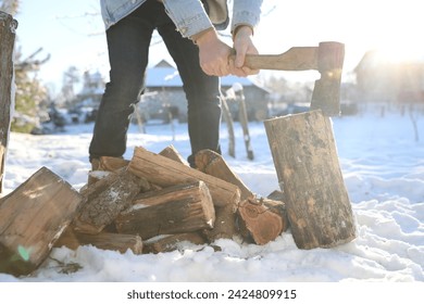 Man chopping wood with axe outdoors on winter day, closeup - Powered by Shutterstock