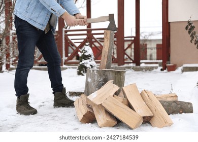 Man chopping wood with axe outdoors on winter day, closeup - Powered by Shutterstock