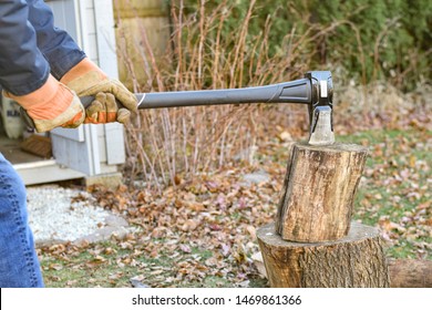 Man Chopping Wood Outside For Fire In The Winter