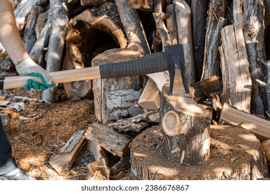 A man chops wood with an ax and cleaver. Preparing fuel for the winter.