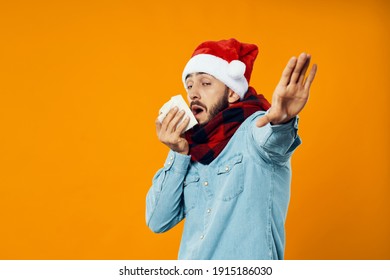 A Man In A Christmas Hat Gesturing With His Hands Napkin Runny Nose Orange Background