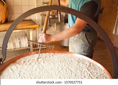 Man churning cheese in Oberstaufen, Allgau, Bavaria, Germany - Shutterstock ID 1570527751