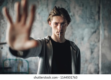 Man With Cigarette In Mouth Reaching Hand Forward