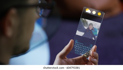 A man in the city, use the transparent phone with the latest technology for video calls with holography family on vacation. Concept: technology, future and futuristic technology, family - Powered by Shutterstock