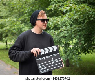 A man with clapperboard outdoor