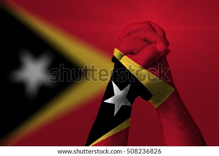 Man clasped hands patterned with the EAST TIMOR flag