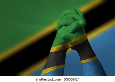 Man clasped hands patterned with the TANZANIA flag