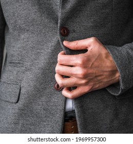 A Man In A Classic Gray Blazer And A White Shirt Unbuttons A Button On His Jacket Close Up. Mockup