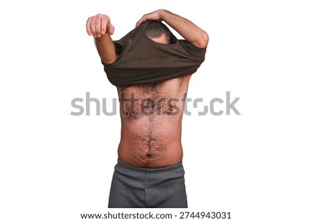 Man in classic long johns pulls casual t-shirt over his head in morning ritual. comfy long johns meet everyday cotton shirt for cozy readiness. relaxed daily wear in clean setting. isolate on white.