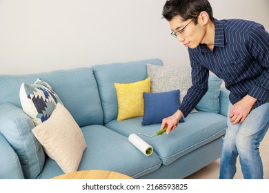 A Man Cleaning With An Adhesive Carpet Cleaner