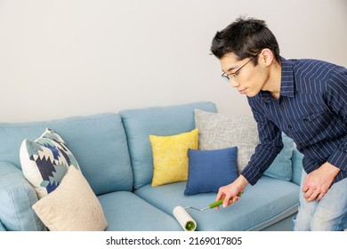 A Man Cleaning With An Adhesive Carpet Cleaner