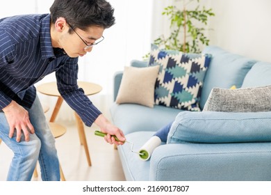 A Man Cleaning With An Adhesive Carpet Cleaner