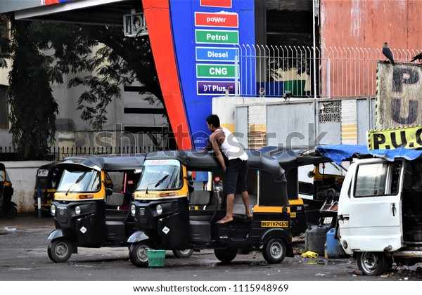 A man cleaning an auto rickshaw on an early\
morning as on 16th July 2018 in Oshiwara near Petrol Pump, Andheri\
West, Mumbai, India.