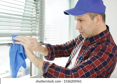 Man Cleaning Blinds By Cloth