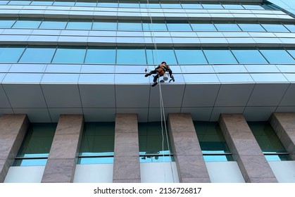 Man cleaning building hanging with  wire