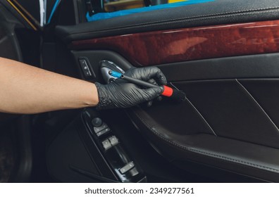 A man cleaning car with cloth and brush. Car detailing. Selective focus. Car detailing. Cleaning with brush. Worker cleaning. Brush and cleaning solution to clean - Shutterstock ID 2349277561