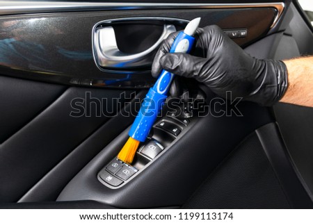 A man cleaning car with cloth and brush. Car detailing. Selective focus. Car detailing. Cleaning with brush. Carwash and cleaning solution concept