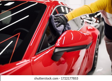 A man cleaning car with cloth, car detailing (or valeting) concept. Selective focus. 