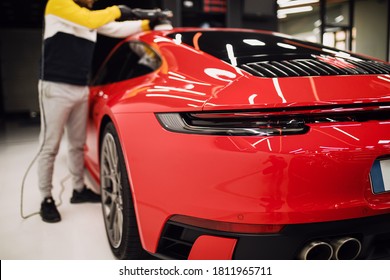 A man cleaning car with cloth, car detailing (or valeting) concept. Selective focus.  - Shutterstock ID 1811965711