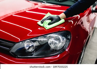 A man cleaning car with cloth, car detailing (or valeting) concept. Selective focus.  - Shutterstock ID 1897033225
