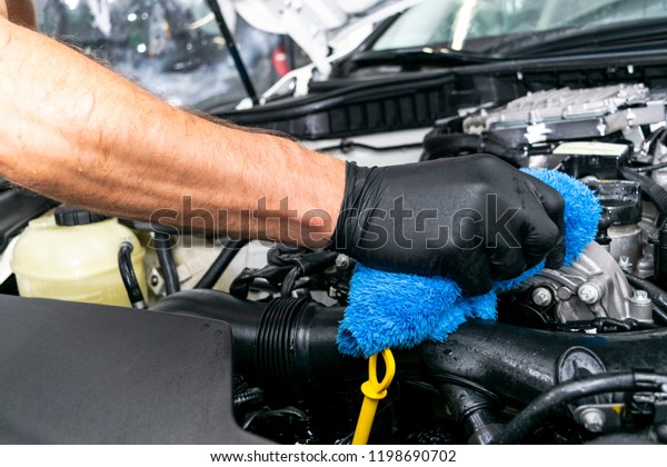 A man cleaning car\
with cloth. Car detailing. Valeting concept. Selective focus. Car\
detailing. Cleaning with sponge. Worker cleaning. Cleaning solution\
to clean