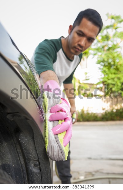 Man cleaning a car.\
Cleaning concept.