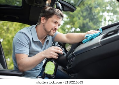 Man Cleaning Car Dashboard With A Spray