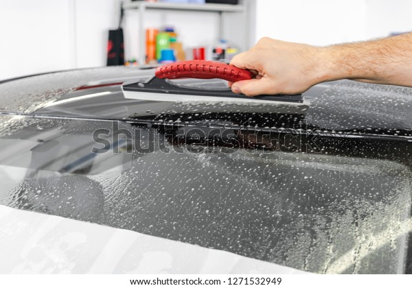 A man cleaning car. Car\
detailing concept. Car detailing. Cleaning with sponge. Car Worker\
cleaning vehicle at the station Solution to clean. Vehicle washing\
station