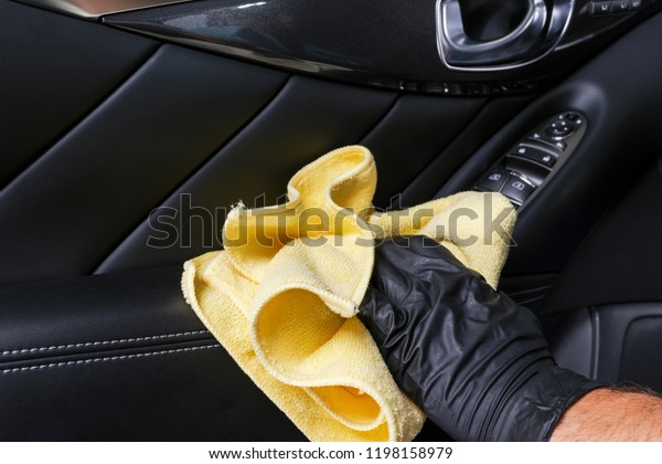 A man\
cleaning car door handle with cloth. Car detailing. Valeting\
concept. Selective focus. Car detailing. Cleaning with sponge.\
Worker cleaning. Cleaning solution to clean\
car