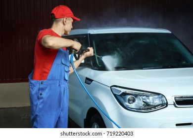 Man Cleaning Car With High Pressure Water In Garage