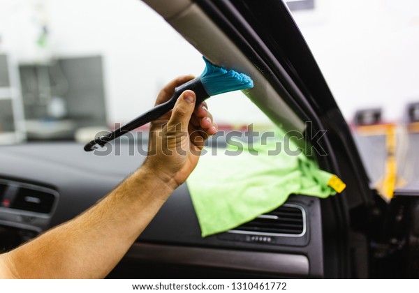 A man cleaning car interior, car\
detailing (or valeting) concept. Selective\
focus.